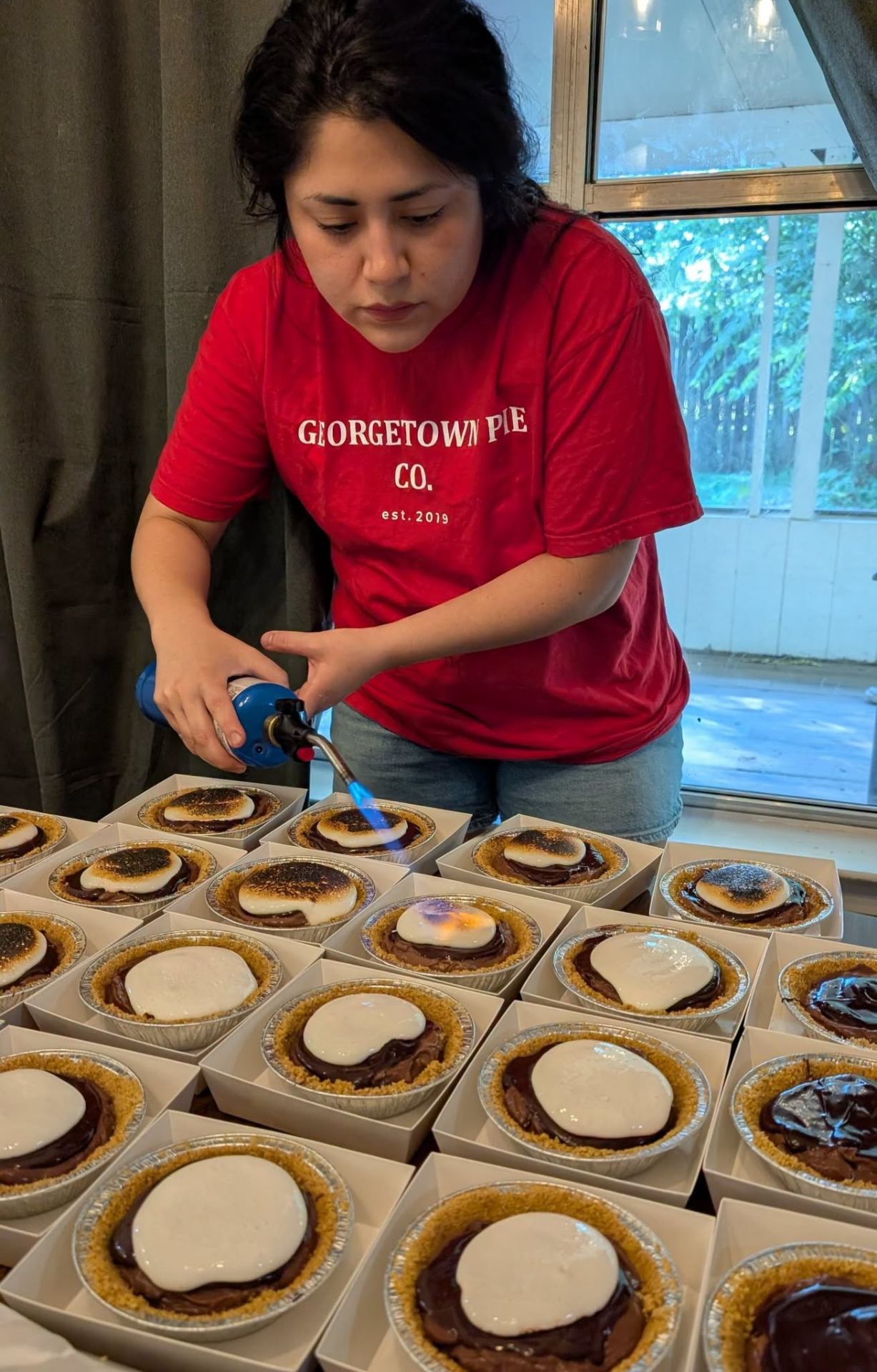 Chef Karina torching the marshmallow topping on S'mores cream pies